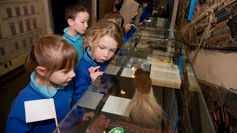 Primary students looking into glass case