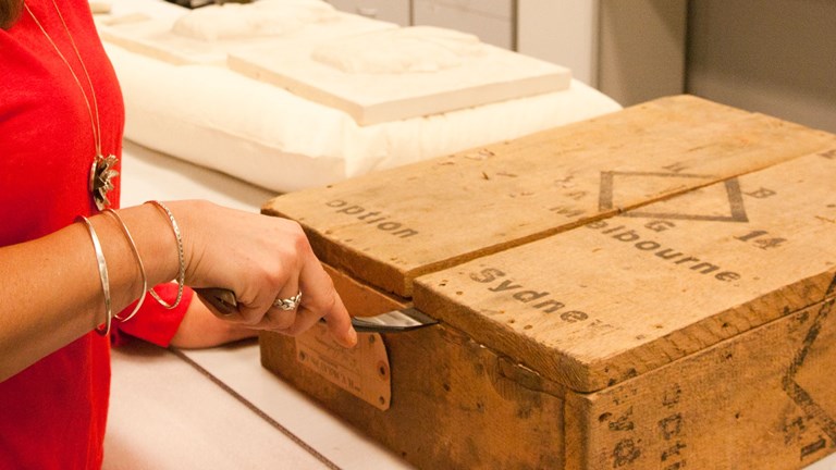 Conservator opening up sealed crate