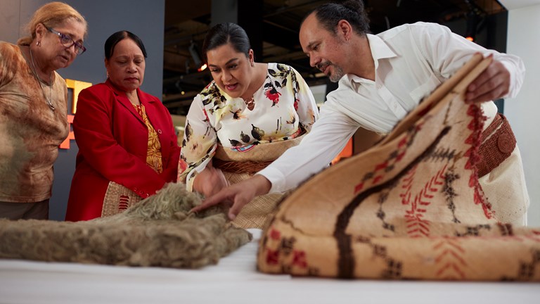 Sione Napi Francis showing Princess Saloe items from the Museum’s collection, including a Rotuman Fine mat, during her visit to Melbourne Museum, 2018.