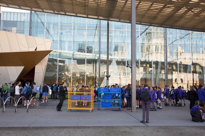 School groups arriving at the museum prior to entry, with carts to house school bags while they are on their excursion