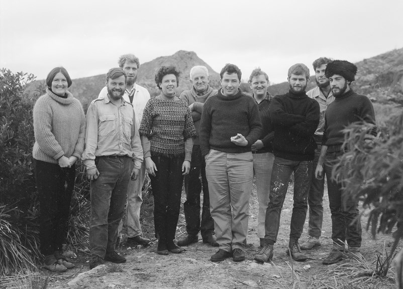 A group of 10 people standing in a line posing for a photo