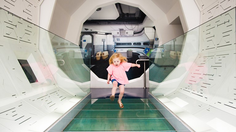 Girl running through a white tunnel