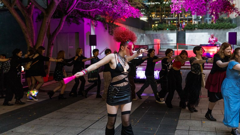 A young person dancing and a conga line of smiling attendees at the 2004 Night At The Museum.