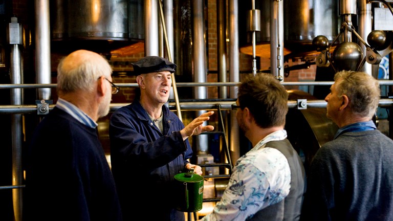 four men in front of a pumping engine